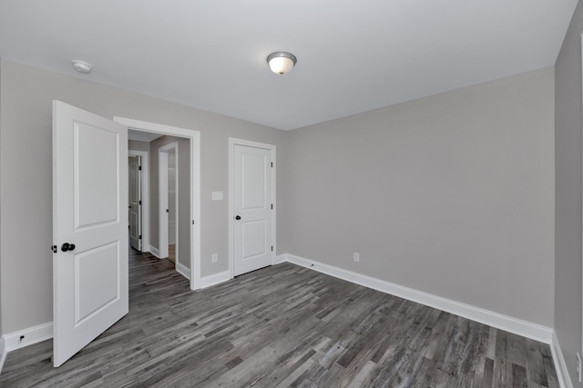 unfurnished bedroom featuring dark hardwood / wood-style floors and a closet