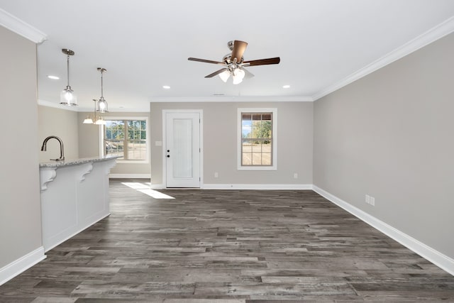 unfurnished living room with crown molding, a healthy amount of sunlight, and dark hardwood / wood-style flooring