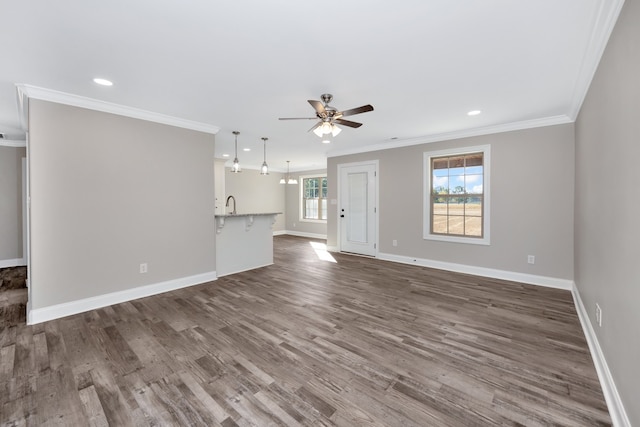 unfurnished living room featuring crown molding, sink, dark wood-type flooring, and ceiling fan