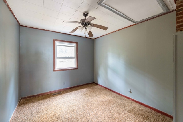 carpeted empty room with crown molding and ceiling fan