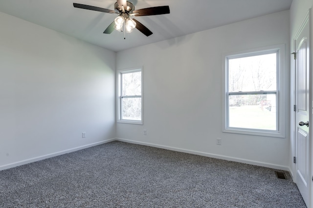 unfurnished room featuring ceiling fan and dark carpet