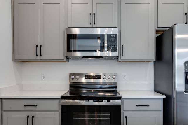 kitchen with gray cabinets and appliances with stainless steel finishes