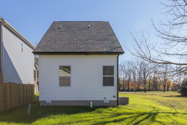 rear view of property featuring cooling unit and a lawn