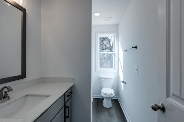 bathroom featuring vanity, hardwood / wood-style flooring, and toilet