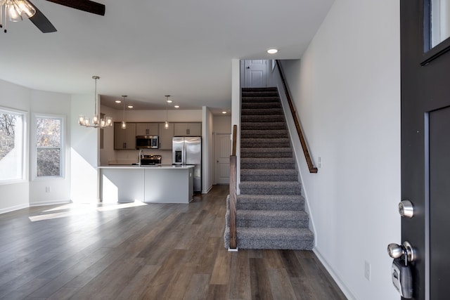 interior space featuring dark hardwood / wood-style flooring and ceiling fan with notable chandelier