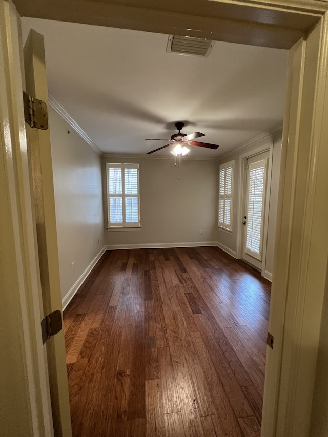 empty room featuring ornamental molding, wood-type flooring, and ceiling fan