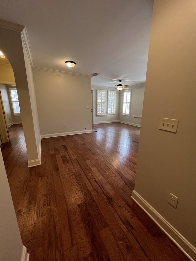 empty room featuring ornamental molding, ceiling fan, and dark hardwood / wood-style flooring