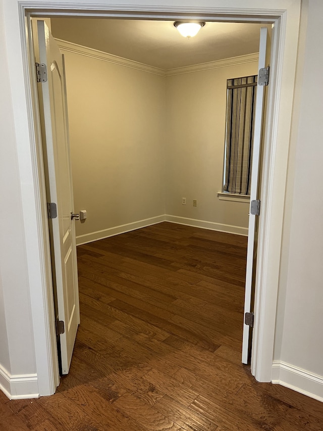 spare room with crown molding and dark hardwood / wood-style floors