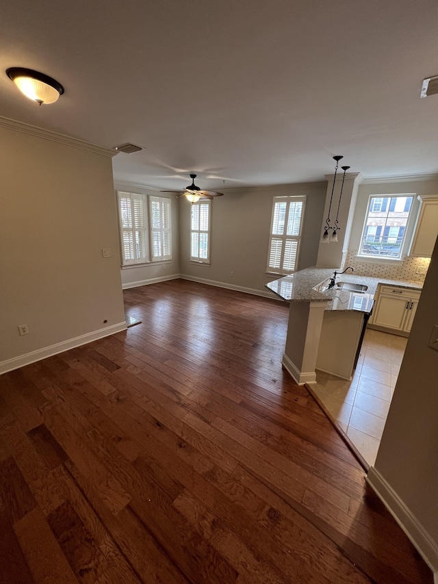 interior space featuring light hardwood / wood-style flooring, crown molding, light stone countertops, decorative light fixtures, and ceiling fan