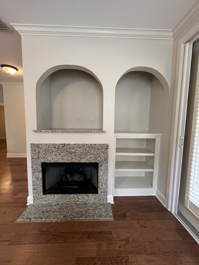 details featuring crown molding, hardwood / wood-style flooring, and a high end fireplace