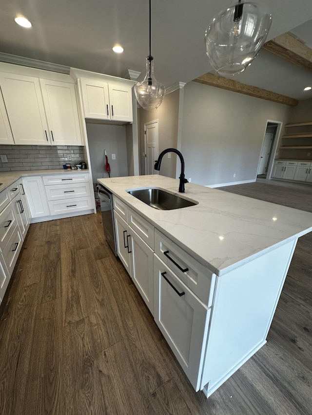 kitchen with light stone counters, sink, decorative light fixtures, and white cabinets