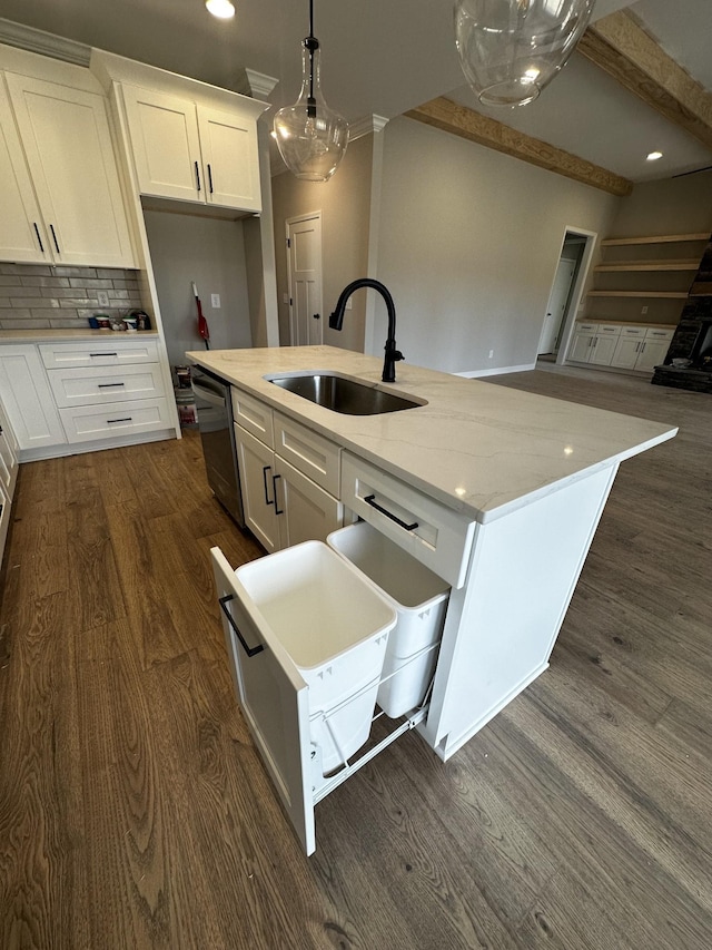 kitchen featuring sink, white cabinetry, light stone counters, decorative light fixtures, and a center island with sink