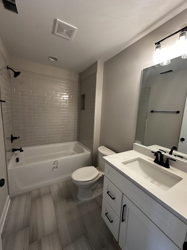 full bathroom with tiled shower / bath combo, vanity, and toilet