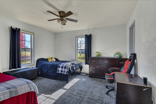 carpeted bedroom with multiple windows and ceiling fan