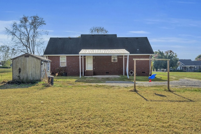 rear view of property with a storage unit and a yard