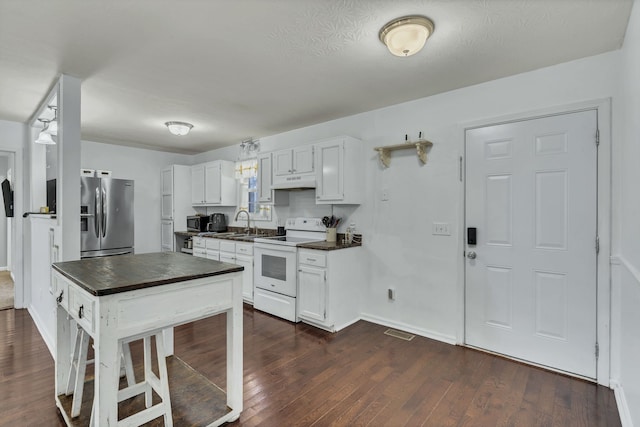 kitchen featuring stainless steel fridge, dark wood-type flooring, white range with electric cooktop, and white cabinets