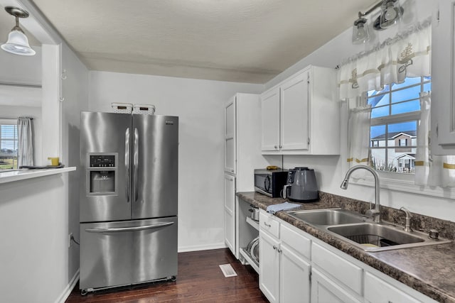 kitchen with dark wood-type flooring, sink, white cabinets, decorative light fixtures, and appliances with stainless steel finishes