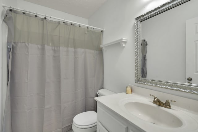 bathroom featuring toilet, a textured ceiling, walk in shower, and vanity