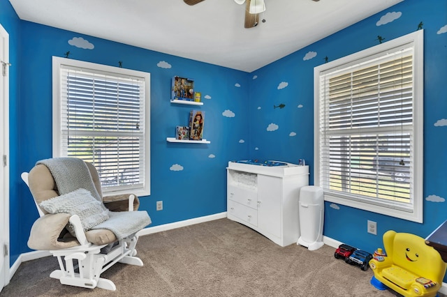 living area featuring a healthy amount of sunlight, carpet flooring, and ceiling fan