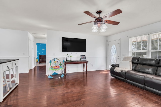 living room featuring dark wood-type flooring and ceiling fan