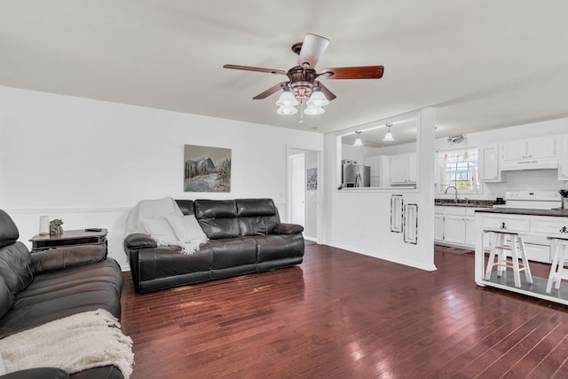 living room featuring sink, dark wood-type flooring, and ceiling fan