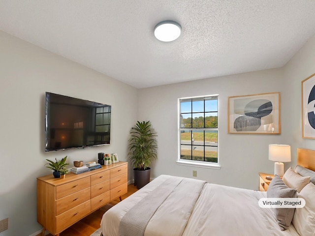 bedroom featuring wood-type flooring and a textured ceiling