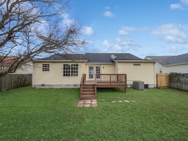 rear view of property with a lawn, a wooden deck, and central AC