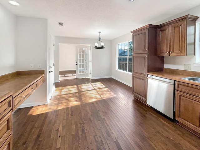 kitchen featuring hanging light fixtures, dark wood-type flooring, an inviting chandelier, stainless steel dishwasher, and a textured ceiling