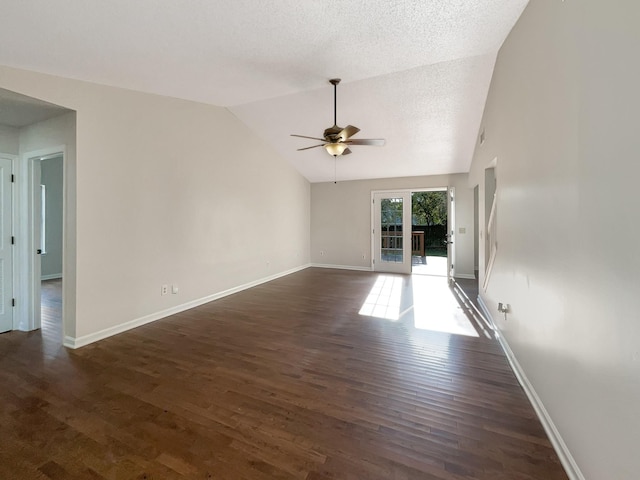 unfurnished living room with a textured ceiling, vaulted ceiling, ceiling fan, and dark wood-type flooring