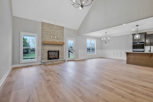 unfurnished living room with light wood-type flooring, high vaulted ceiling, and a wealth of natural light