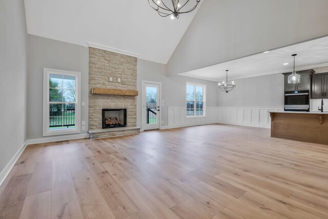 2120 Hamilton Chambers Rd, Lebanon, TN 37087 - unfurnished living room featuring a chandelier, light wood-style floors, high vaulted ceiling, healthy amount of natural light, and a fireplace