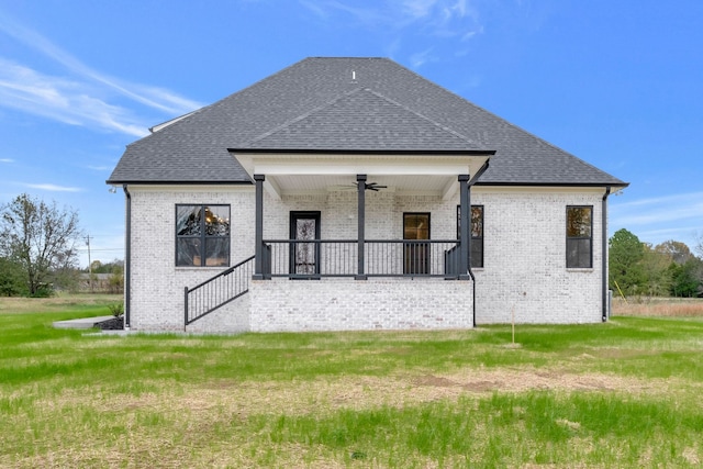 rear view of house featuring covered porch, ceiling fan, and a lawn