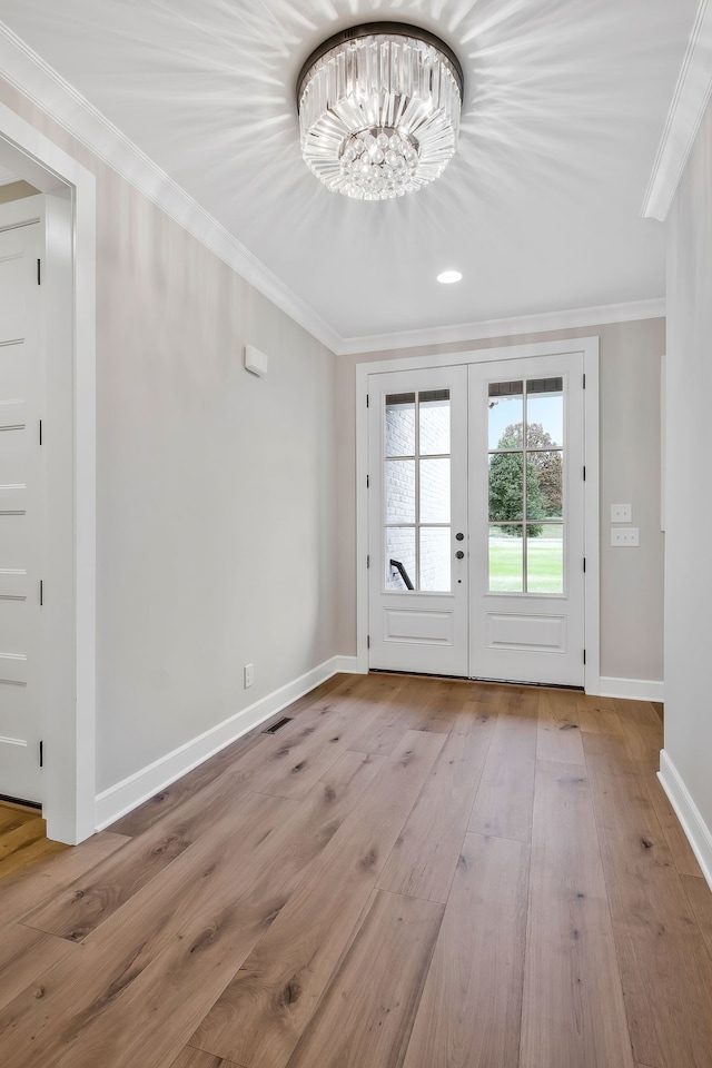 doorway featuring ornamental molding, french doors, a chandelier, and light wood-type flooring