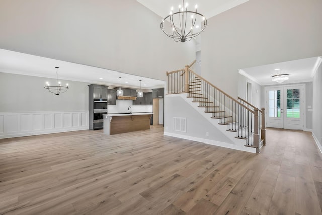 2120 Hamilton Chambers Rd, Lebanon, TN 37087 - unfurnished living room with a chandelier, ornamental molding, a sink, stairway, and light wood-type flooring