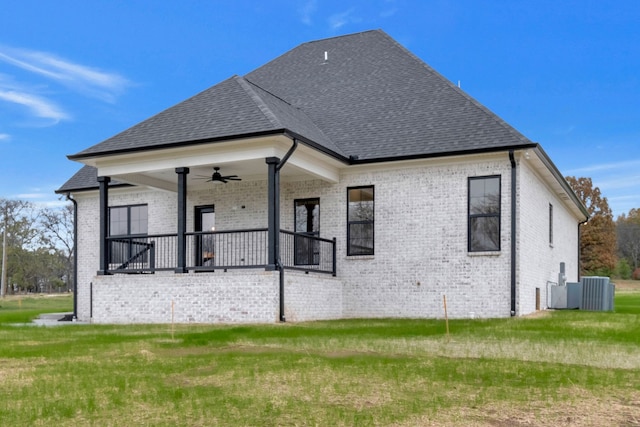 back of house featuring central AC unit, ceiling fan, a porch, and a yard