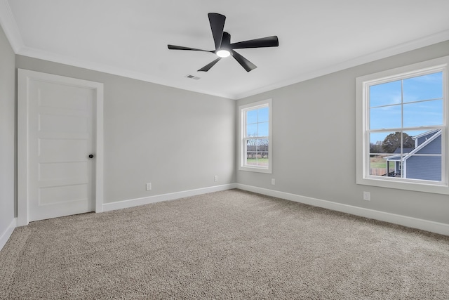 unfurnished room featuring carpet flooring, plenty of natural light, ceiling fan, and crown molding