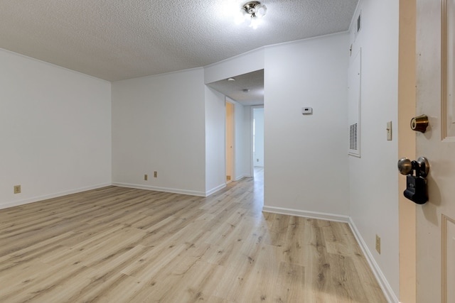 empty room featuring light hardwood / wood-style floors and a textured ceiling