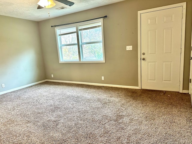 carpeted empty room with ceiling fan and a textured ceiling