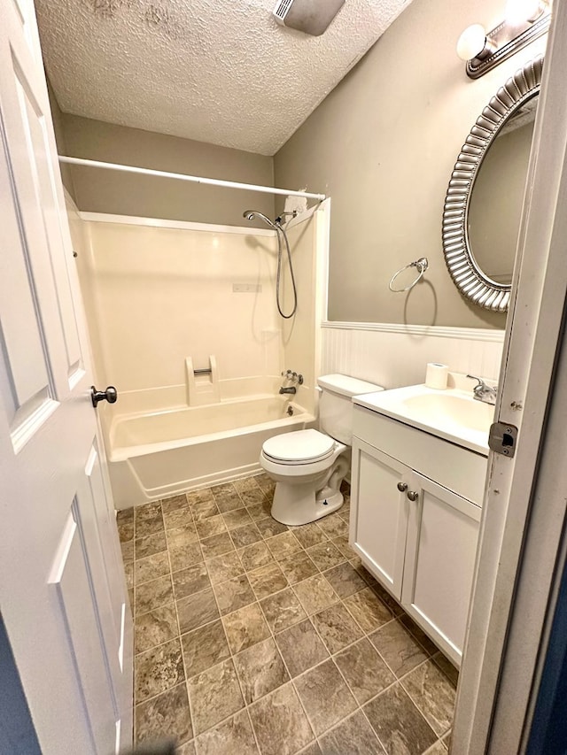 full bathroom with vanity, shower / bathing tub combination, a textured ceiling, and toilet