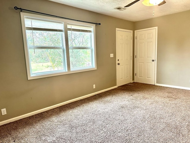 carpeted empty room with a textured ceiling and ceiling fan