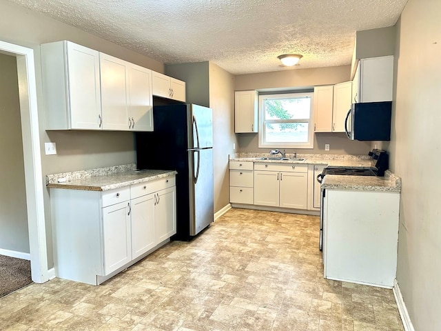 kitchen with sink, light stone countertops, a textured ceiling, white cabinetry, and stainless steel appliances