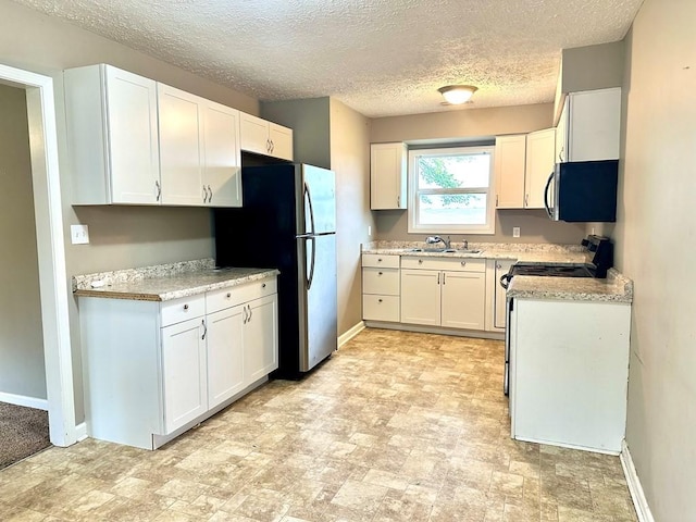 286 Nichols Rd, Pembroke, KY 42266 - kitchen with freestanding refrigerator, a sink, black / electric stove, light countertops, and white cabinetry