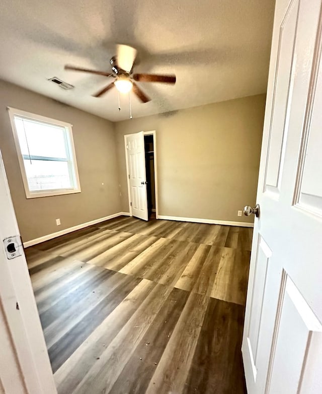 unfurnished bedroom with ceiling fan, hardwood / wood-style floors, and a textured ceiling