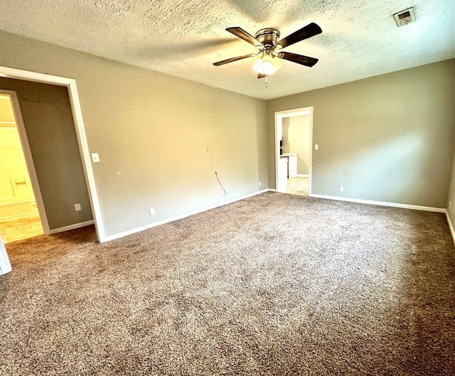 carpeted spare room with ceiling fan and a textured ceiling