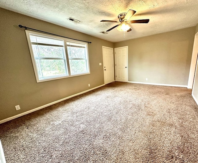 empty room featuring carpet and a textured ceiling