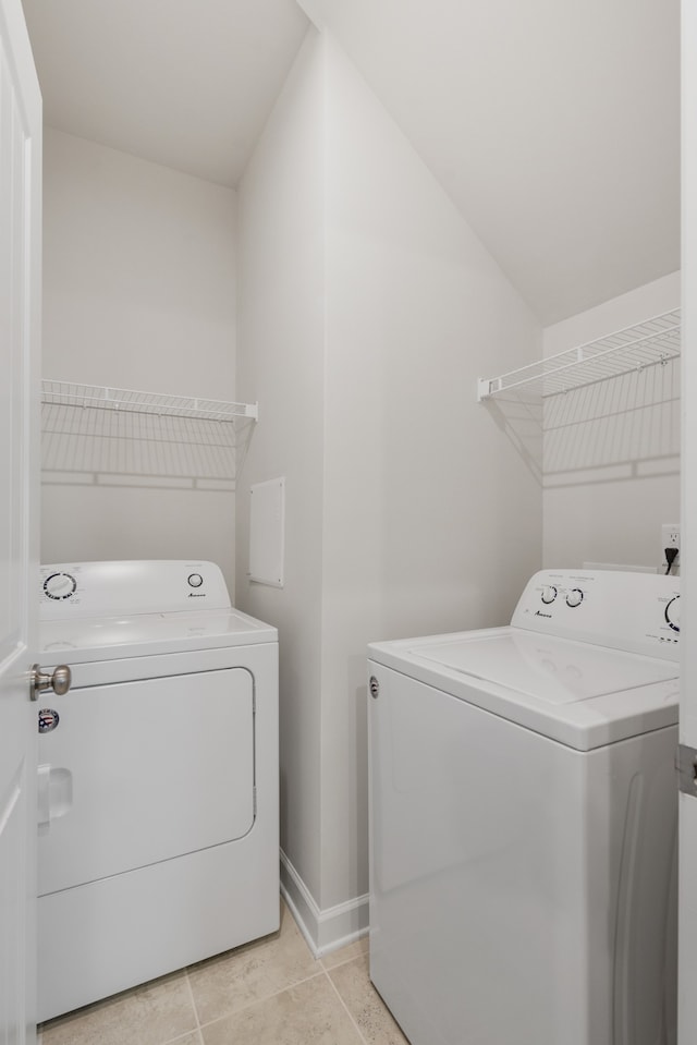 washroom featuring washing machine and dryer and light tile patterned floors