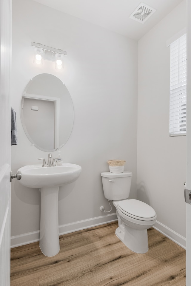 bathroom with toilet and hardwood / wood-style flooring