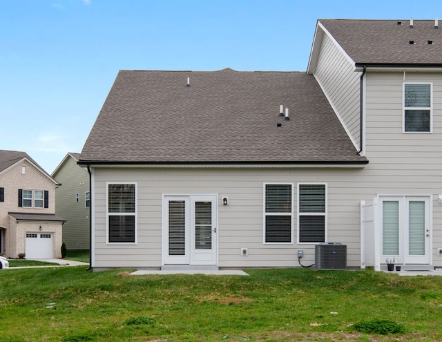 rear view of property featuring cooling unit and a lawn