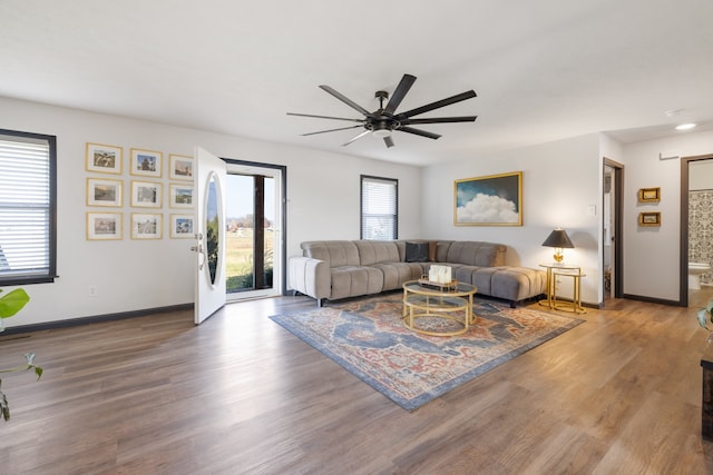 living room with ceiling fan, wood-type flooring, and a wealth of natural light