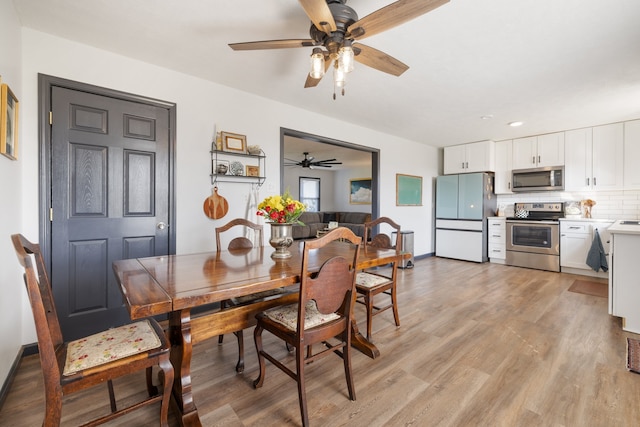 dining room with ceiling fan and light wood-type flooring